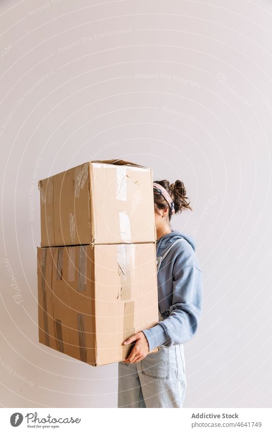 Positive Frau trägt Kartons Kasten führen verlegen Zugehörigkeit Stapel Hypothek Hausbesitzerin lässig Schachtel Optimist jung Paket einziehen Haufen heimwärts