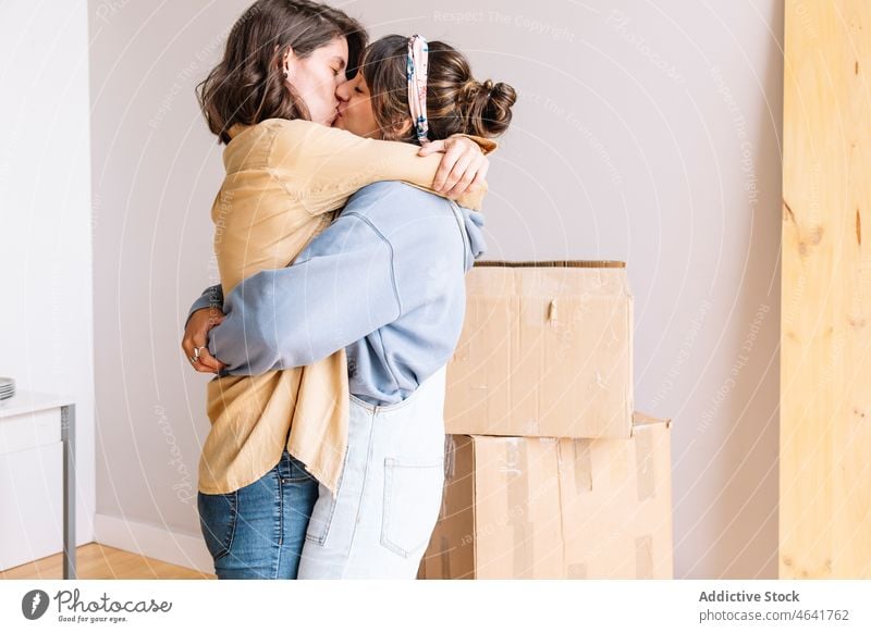Lesbisches Paar küsst sich während des Umzugs Kuss lesbisch verlegen Umarmung Liebe Kasten Appartement neu Freundin Frauen Glück Zusammensein Schachtel