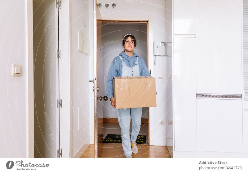 Junge Frau zieht in neue Wohnung führen Kasten einziehen Eingang Zusammensein Zugehörigkeit Appartement verlegen heimwärts lässig flach Hypothek Anwesen Karton