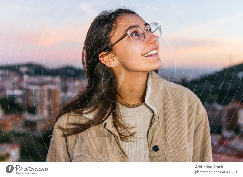 Entzückte Frau mit Brille bei Sonnenuntergang Teenager sorgenfrei Glück charmant Persönlichkeit Porträt Glee Freude froh Individualität Zahnfarbenes Lächeln