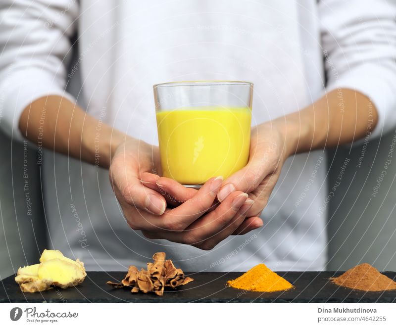 Hände, die ein Glas mit goldener Kurkuma-Milch halten - Konzept der alternativen Kräutermedizin und Naturheilkunde trinken melken Latte Gewürz gelb Entzug