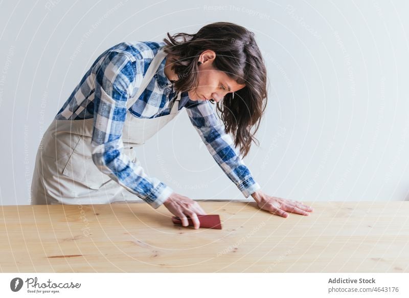 Frau poliert Holzbrett in der Werkstatt Tischlerin Holzarbeiten polnisch Schleifpapier Arbeit Handarbeit hölzern Holzplatte Schiffsplanken Herstellung