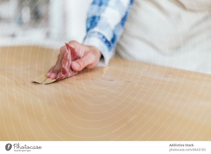 Anonyme Frau beim Polieren eines Holzbretts in einer Werkstatt Tischlerin Holzarbeiten polnisch Schleifpapier Arbeit Handarbeit hölzern Holzplatte