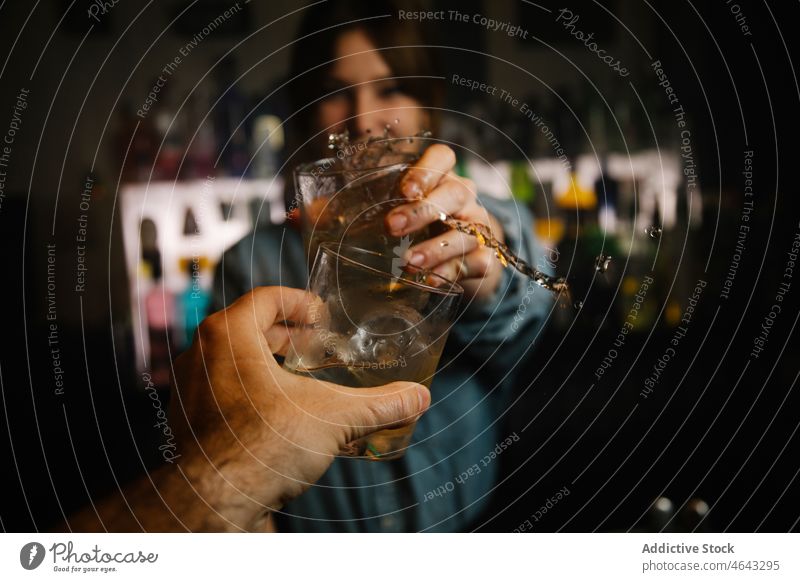 Barkeeper stößt mit einem gesichtslosen Mann auf Cocktails an Frau Getränk Alkohol Klirren Zuprosten platschen dienen Schnaps Arbeit Abfertigungsschalter Glas