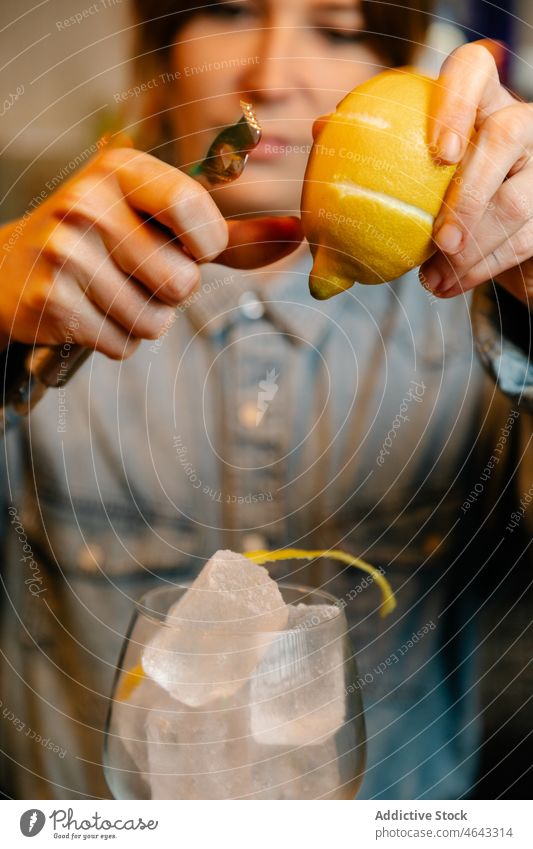 Barkeeper gibt Zitronenschalen ins Glas Frau Schale Zitrusfrüchte Arbeit Frucht Eiswürfel kalt Arbeiter Dienst Arbeitstag Personal Arbeitsplatz Dame Windstille