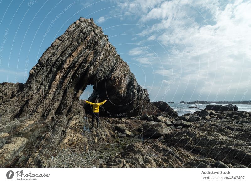 Anonymer Reisender in der Nähe eines Felsens am Ufer Ausflug Abenteuer Strand Klippe MEER Wasser Küste Natur Stein Asturien Spanien Formation rau wolkig