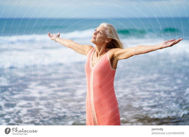 Schöne reife Frau öffnet ihre Arme an einem schönen Strand und genießt ihre Freizeit Senior alt Person Ruhestand Lifestyle Glück MEER Feiertag entspannend