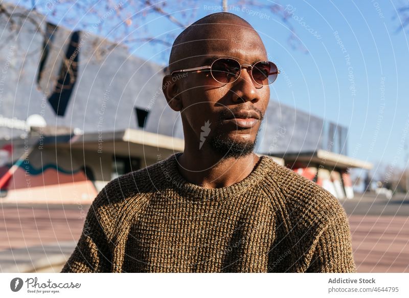 Stilvoller schwarzer Mann mit Sonnenbrille auf der Straße Mode Vorschein Design trendy Outfit Großstadt ernst männlich kahl selbstbewusst Afroamerikaner Brille
