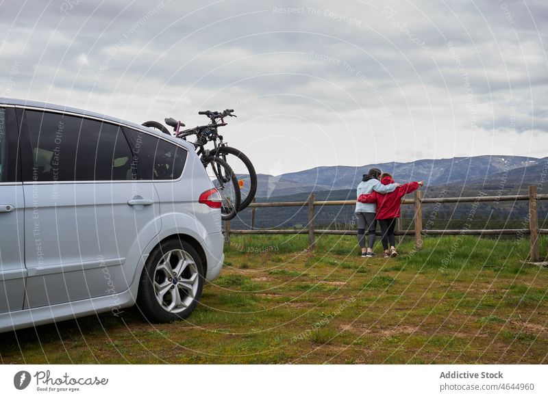 Anonyme Mutter mit Kind bewundert Berge in der Nähe von Auto mit Fahrrad PKW Landschaft Sohn Hobby Umarmen Aktivität Zeitvertreib Berge u. Gebirge bewundern