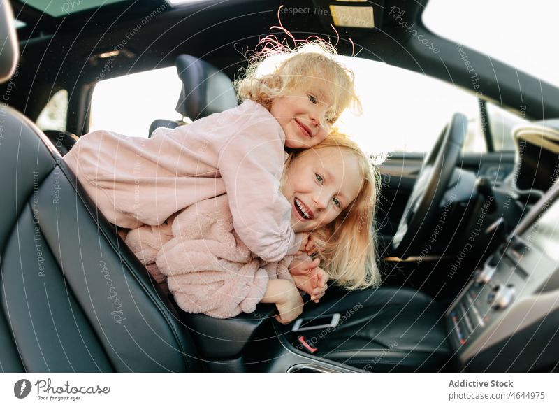 Positive Schwestern spielen im Auto Mädchen spielerisch Spaß haben PKW Autoreise Zeitvertreib Passagier Automobil Ausflug Arbeitsweg Fahrzeug Reise Kinder
