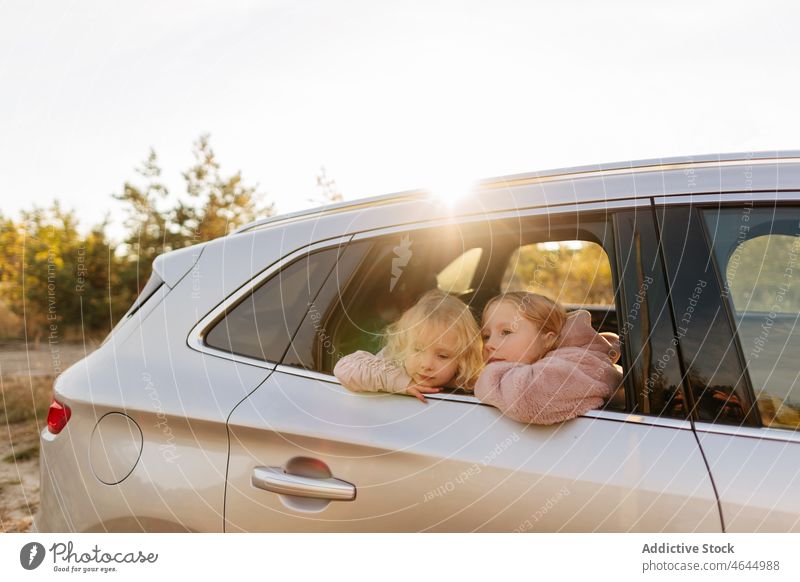 Schwestern schauen aus dem Autofenster Mädchen PKW Autoreise Zeitvertreib Passagier Landschaft Natur Automobil Arbeitsweg Fahrzeug Reise Kinder Verkehr Freizeit