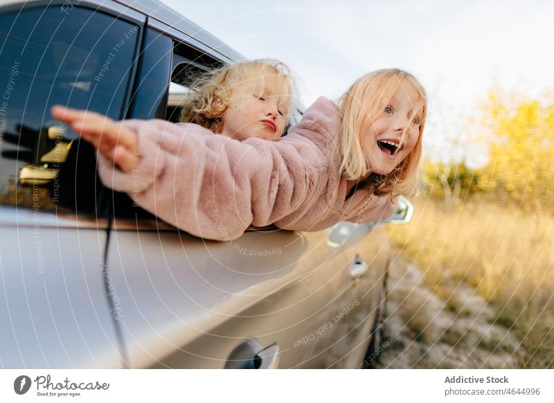 Schwestern schauen aus dem Autofenster Mädchen PKW Autoreise Zeitvertreib Passagier Landschaft Natur Automobil Arbeitsweg Fahrzeug Reise Kinder Verkehr Freizeit