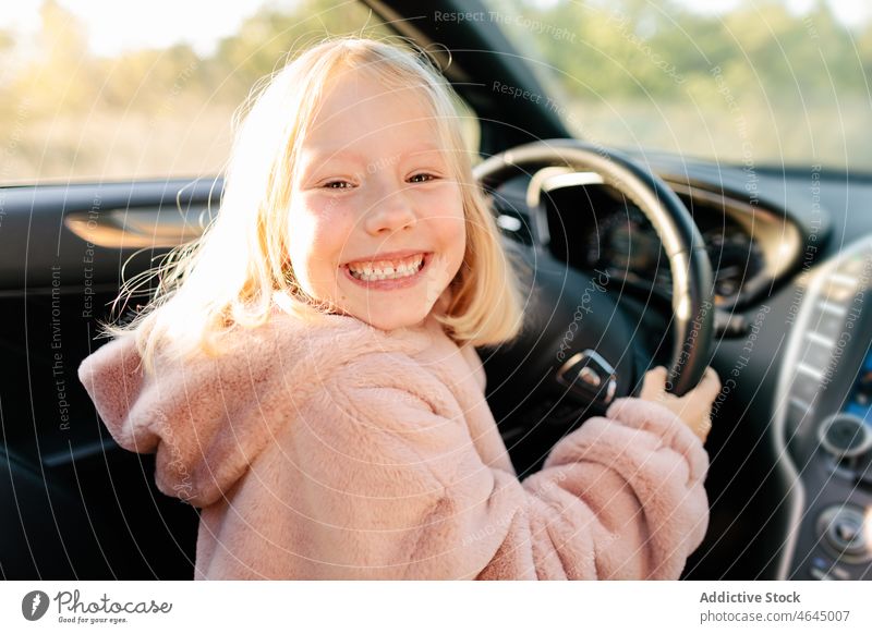 Glückliches Mädchen auf dem Fahrersitz Kind PKW Automobil Lenkrad Mitfahrgelegenheit Ausflug Arbeitsweg Spaß haben spielerisch modern Fahrzeug positiv heiter