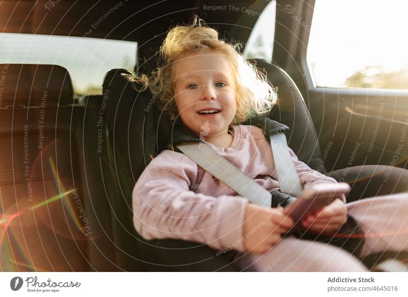 Nettes Mädchen spielt im Auto auf dem Smartphone spielen Spiel PKW Kind Automobil Passagier Mitfahrgelegenheit Autoreise ruhen Arbeitsweg Sitz Fahrzeug Ausflug