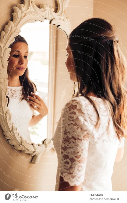 Die Braut vor der Hochzeit, die sich nervös im Spiegel betrachtet und ihr Haar kämmt. Ein wichtiger Tag. Hochzeit und Heiratskonzept. Betrachtungen Ehefrau