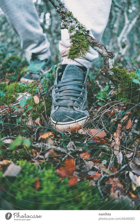 Detail eines Fußes mit einem Turnschuh, der im Wald läuft schließen Schuh dreckig altehrwürdig retro hoch Boden Erde erkunden Erkundung Umwelt Vegetation