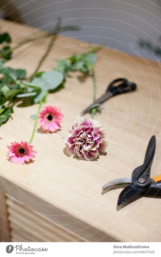Blumenladen - ein Arbeitstisch für einen Floristen mit Blumen und Werkzeugen für die Herstellung von Blumensträußen Werkstatt Blumenhändler arrangierend