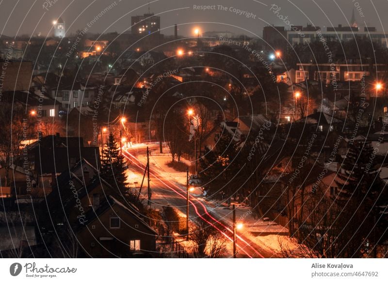 Häuser in der Stadt bei Nacht Großstadt Lettland Nachtlichter Autos Winter Schnee Farbfoto Straßen neblige Nacht Bäume