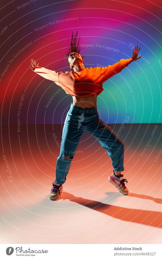Glückliche Frau tanzt mit erhobenen Händen in buntem Studio Tänzer sich[Akk] bewegen Fähigkeit Probe Dehnung Projektor ausführen Lächeln Energie dynamisch üben
