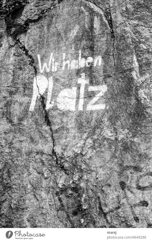 Flüchtlingsproblematik. Schriftzug: "Wir haben Platz" auf Fels gesprayt. Diskussion Politik Wandmalereien Zugeständnis Mauer Wort Schmiererei Streitfrage