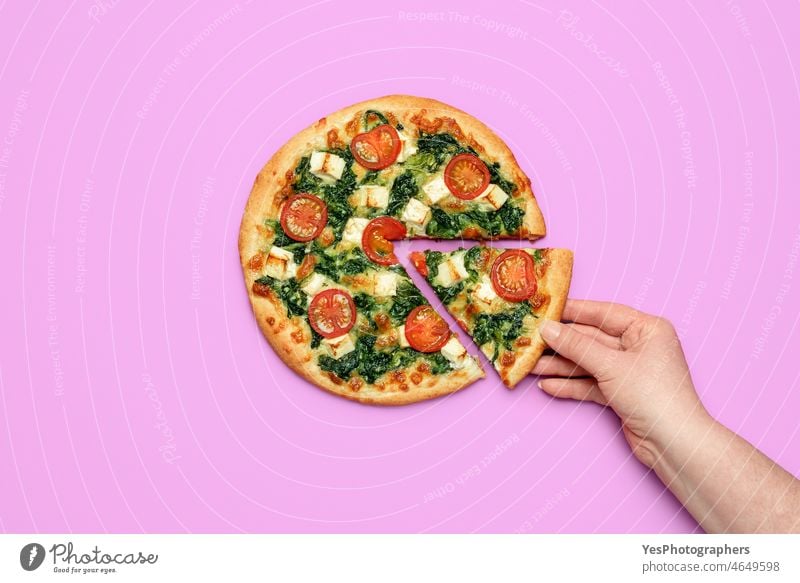 Frau nimmt ein Stück Pizza in die Hand. Hausgemachte vegetarische Pizza mit Spinat und Feta-Käse Hintergrund gebacken Farbe gekocht Textfreiraum Kruste Küche