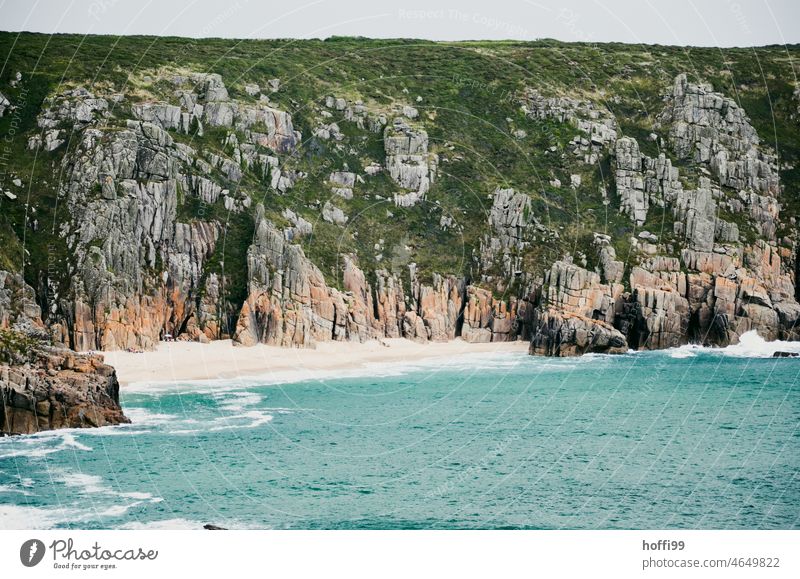 ein kleiner einsamer Strand eingefasst von Felsen an einer Steilküste Einsamkeit Wasser Küste Meer Sommer Tourismus Abgeschiedenheit unentdeckt