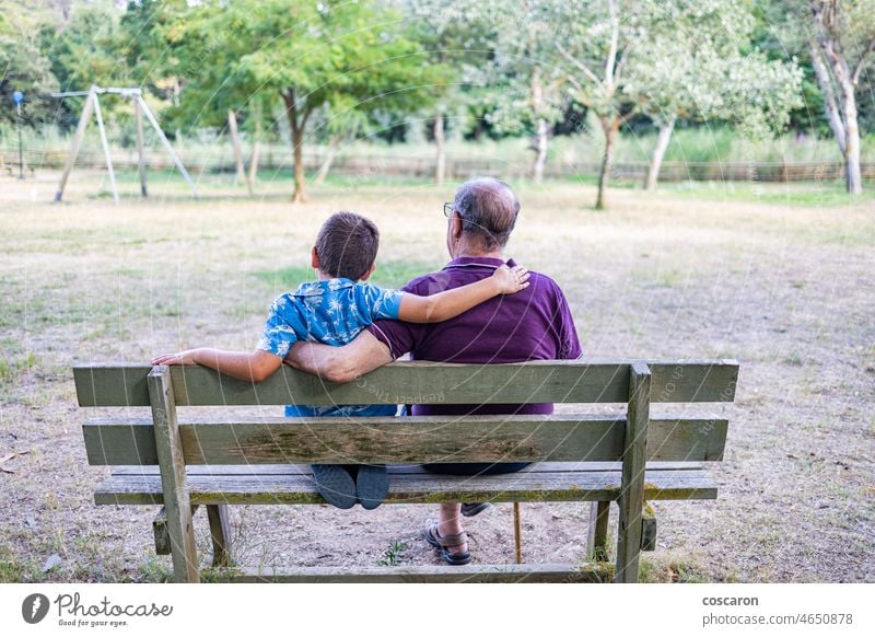 Großvater und sein Enkel sitzen auf einer Bank im Park Aktivität Alterung Rücken Junge Kind Kindheit älter Familie Freunde Generation Enkelkind Großeltern