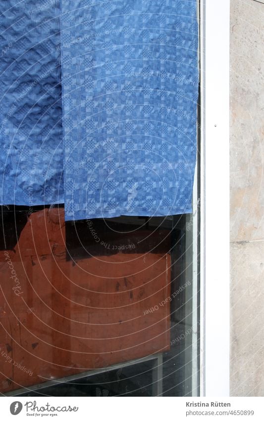 schaufenster halb abgeklebt mit blauem papier sichtschutz verklebt zugeklebt geschäft laden verlassen leer renovieren geschlossen struktur muster abstrakt holz