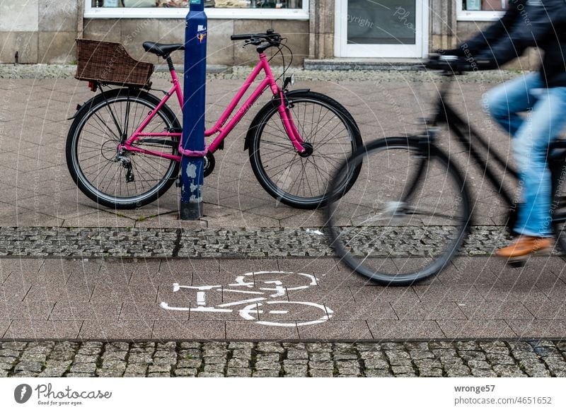 Fahrradweg mit Radler und am Laternenpfahl gesicherten Rad in der City 1/2 Stadt angeschlossen Verkehr Fahrradfahren Straßenverkehr Mobilität Außenaufnahme