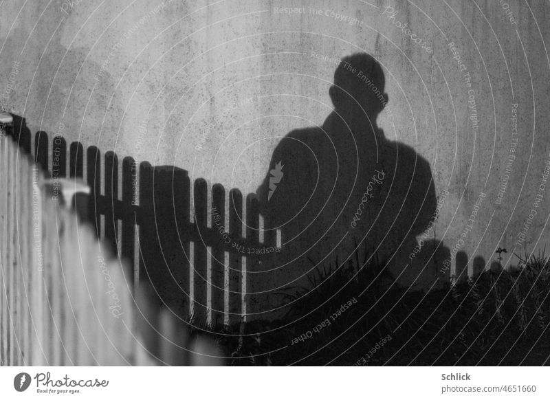 Selfie Schattenwurf durch Autoscheinwerfer Lattenzaun im Vordergrund sw Schattenspiel Nacht nachts Portrait Kontast kontrastreich Zaun Wand außen Außenaufnahme