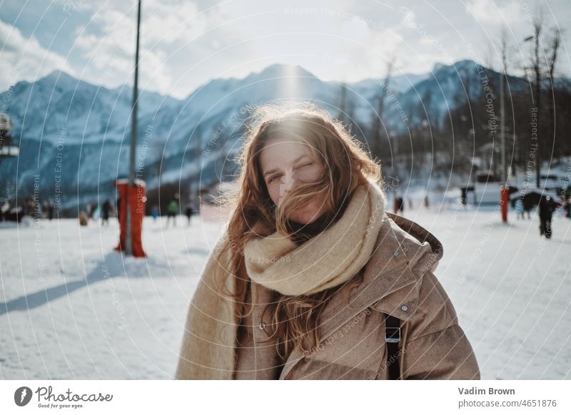 Lächelndes Mädchen in den Bergen schön attraktiv Schnee Winter Porträt Frau kalt Natur weiß Menschen im Freien Berge u. Gebirge Weihnachtszeit jung Mode Glück
