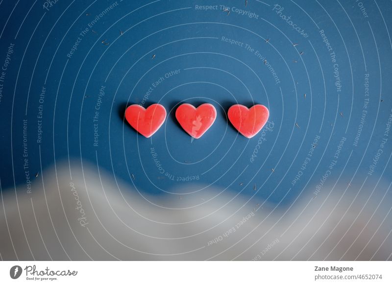 Drei Gelee-Herzen auf blauem Hintergrund, Konzept des Lebens und der Liebe Valentinstag Valentinsgruß live Videospiel 3 Götterspeise Süßigkeiten