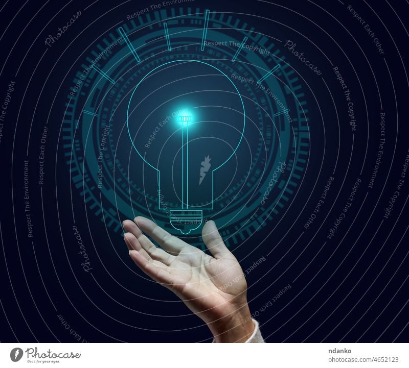 holographische Lampe und weibliche Hand auf einem dunkelblauen Hintergrund. Konzept für neue Ideen, Brainstorming. Eröffnung eines profitablen Geschäfts Energie