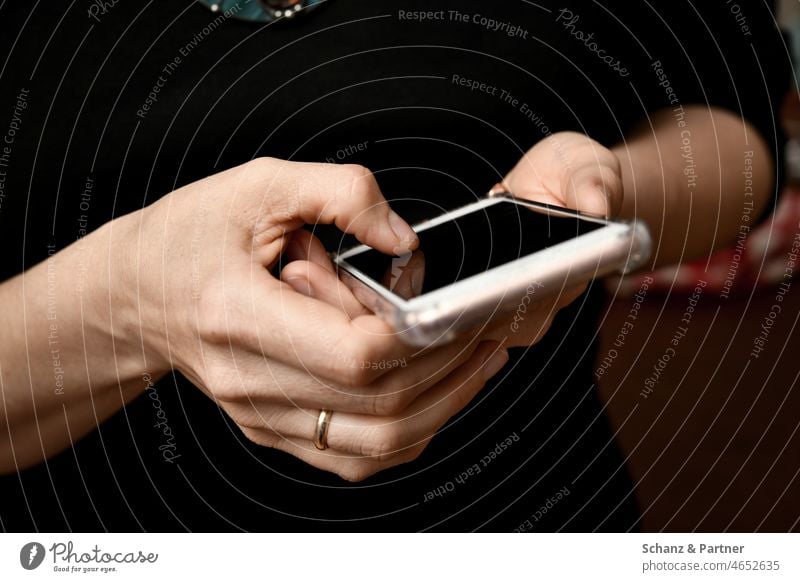 Frau wischt auf einem Smartphone Handy wischen tippen Messenger Facebook whatsapp HandHände Ehering Kommunikation Internet Technik & Technologie Telefon