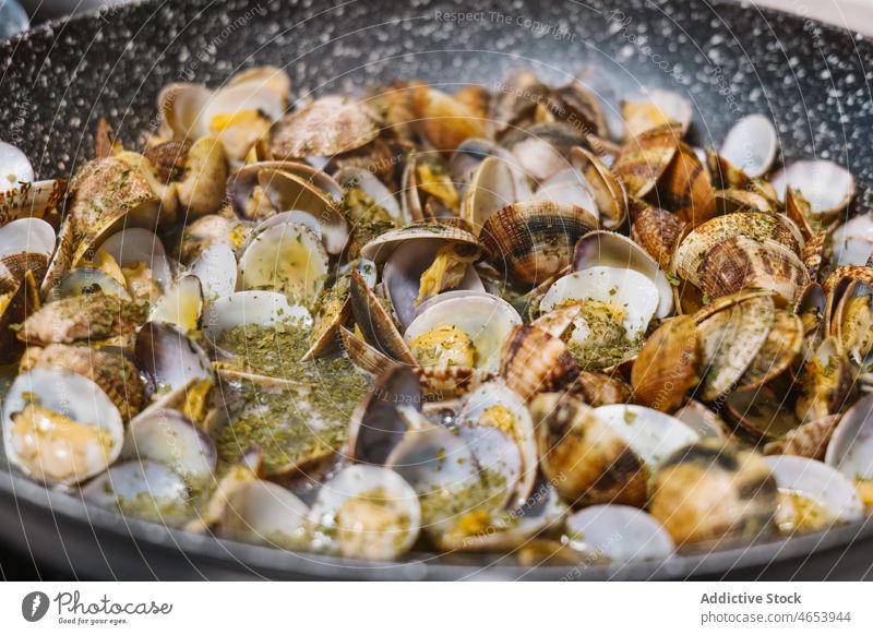 Venusmuscheln in der Bratpfanne auf dem Herd Muschel Molluske Krebstier Meeresfrüchte Küche Delikatesse Koch braten heiß Kocher Mahlzeit Speise geschmackvoll