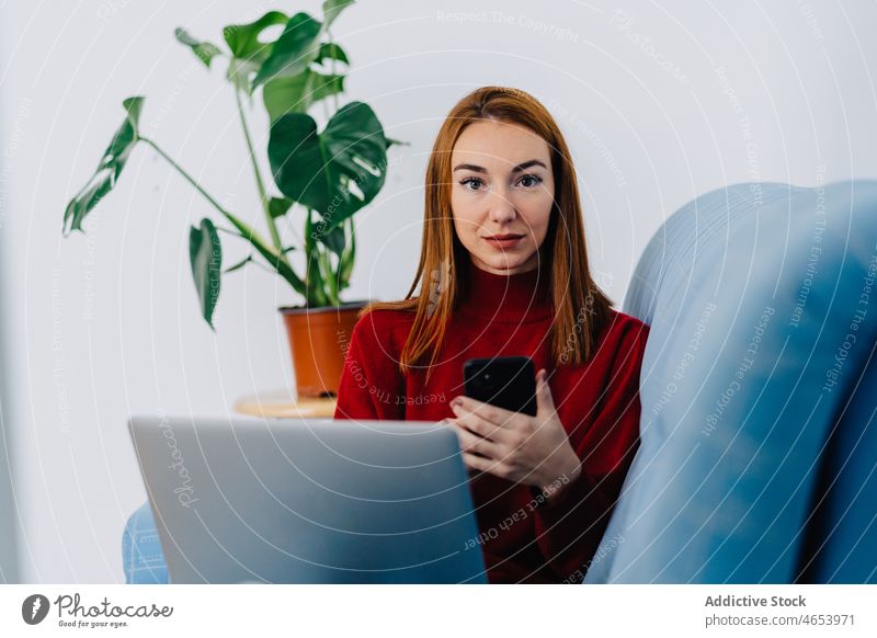 Frau mit Laptop und Smartphone zu Hause benutzend ruhen Freizeit online Internet Wochenende Browsen Netbook Telefon sich[Akk] entspannen Surfen Mobile Anschluss