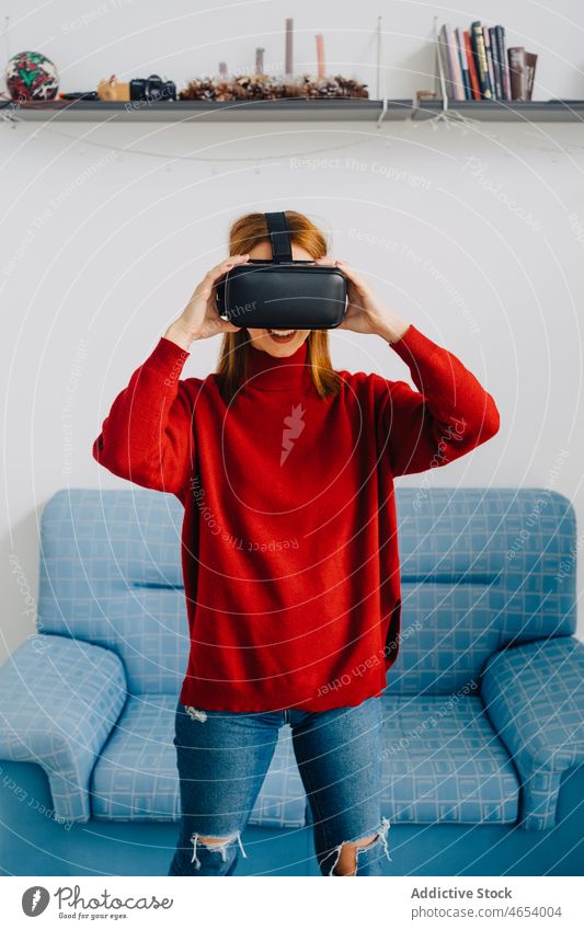 Lächelnde Frau erkundet VR-Brille Virtuelle Realität Headset benutzend erkunden zu Hause Innovation Freizeit eintauchen Simulator Schutzbrille Gerät unterhalten