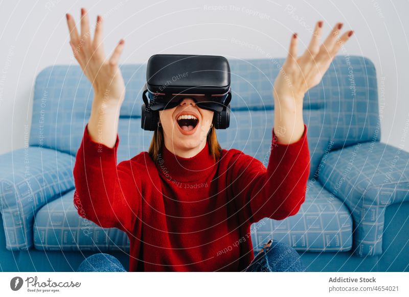 Verblüffte Dame mit VR-Brille und erhobenen Händen Frau Virtuelle Realität Hallo Technik Schutzbrille Arme hochgezogen Headset Simulator erkunden