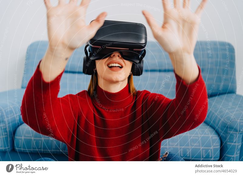 Verblüffte Dame mit VR-Brille und erhobenen Händen Frau Virtuelle Realität Hallo Technik Schutzbrille Arme hochgezogen Headset Simulator erkunden