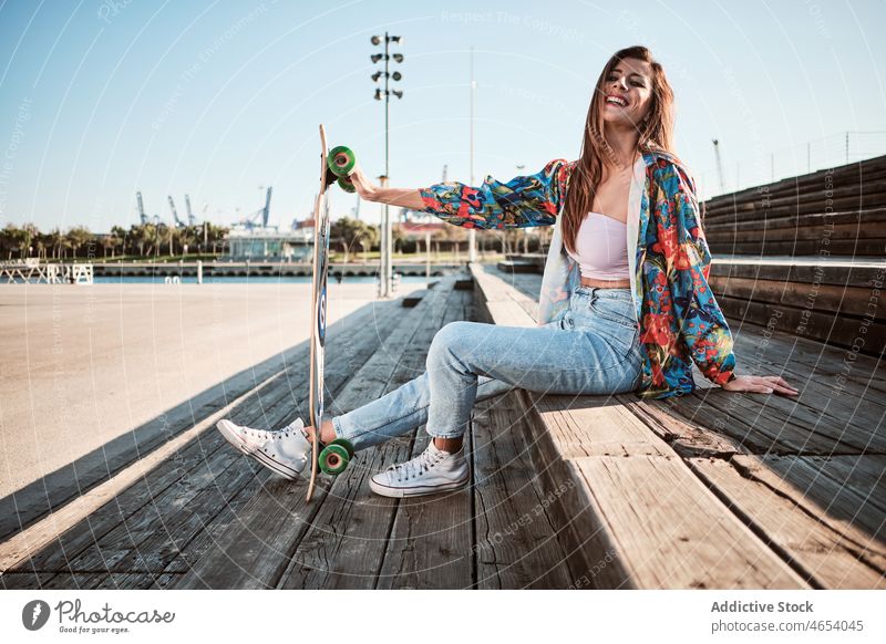 Junge glückliche trendige Frau mit Longboard Stil Großstadt urban sich[Akk] entspannen Sommer Kälte Vorschein Outfit jung Skater cool selbstbewusst trendy