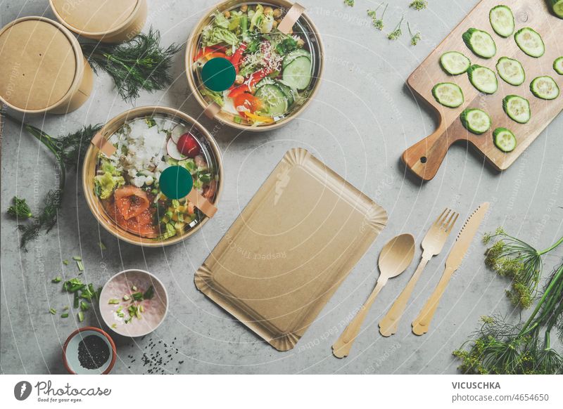 Gesundes Salat-Mittagessen in Essensschalen zum Mitnehmen mit nachhaltigen Behältern gesunder Salat Essen zum Mitnehmen Schüsseln Container grau Küche Tisch
