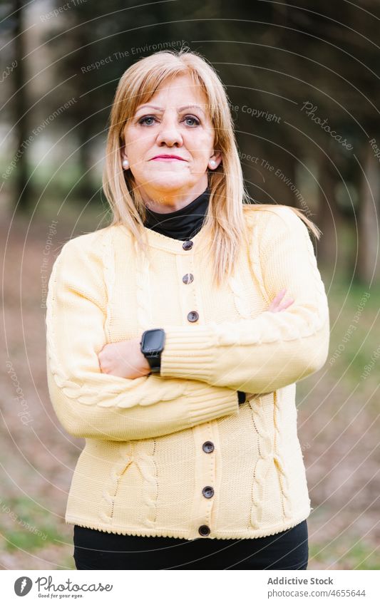 Ruhige Frau im Park stehend Lebensmitte Porträt Windstille lässig reif Vorschein selbstbewusst Grün Lifestyle Garten Individualität Teint Menschliches Gesicht