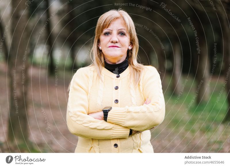 Ruhige Frau im Park stehend Lebensmitte Porträt Windstille lässig reif Vorschein selbstbewusst Grün Lifestyle Garten Individualität Teint Menschliches Gesicht