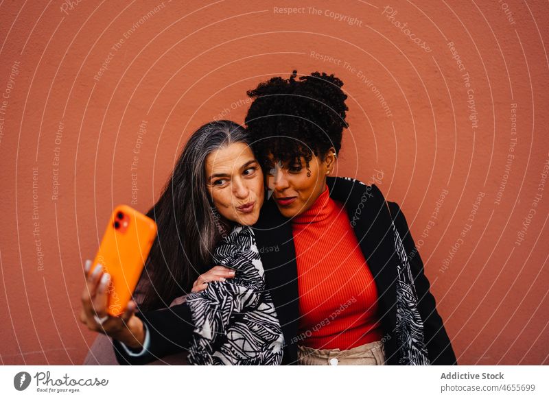 Glückliche multirassische Frauen nehmen Selbstporträt auf Handy Freund Selfie Smartphone Funktelefon Selbstportrait Lächeln Zusammensein Spaß haben benutzend