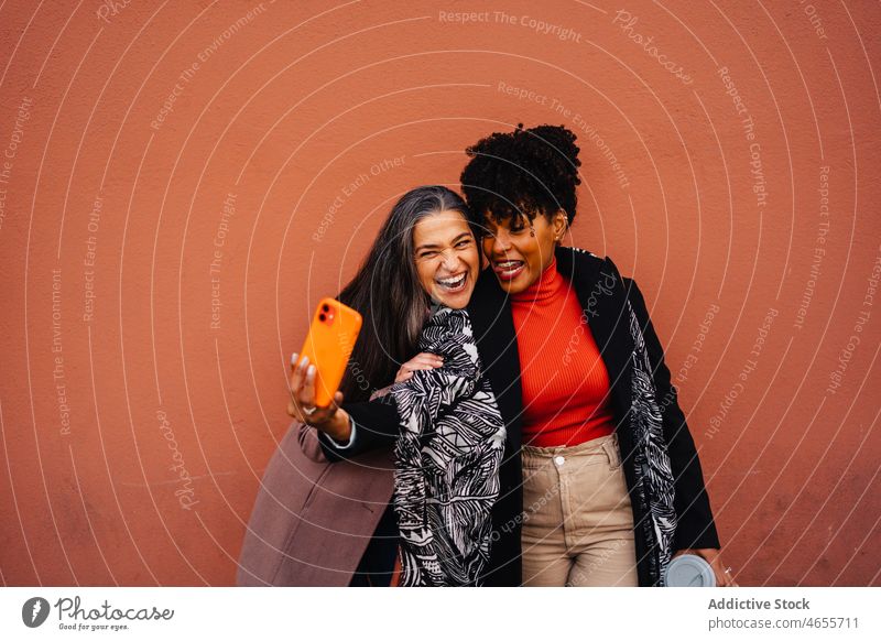 Glückliche multirassische Frauen nehmen Selbstporträt auf Handy Freund Selfie Smartphone Funktelefon Selbstportrait Lächeln Zusammensein Spaß haben benutzend