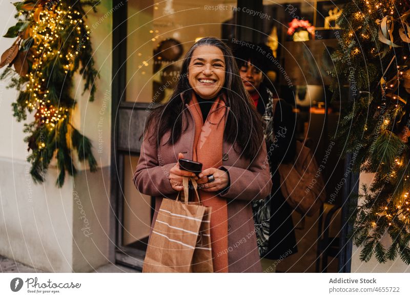 Lachende Kundinnen beim Verlassen des Geschäfts mit Einkaufstüten Frauen Käufer verbrauchen konsumgeil Einkaufstasche Großstadt Sale Werkstatt heiter Tüte
