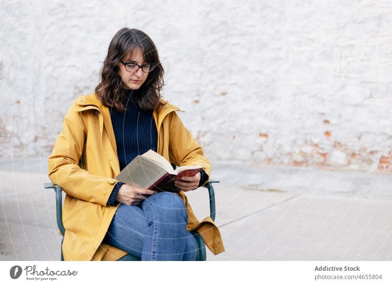 Frau liest Buch auf der Straße lesen Hobby Leseratte Literatur Interesse Roman Gebäude Wand weiß Stil urban Vorschein Großstadt hell Stadt Dame Oberbekleidung