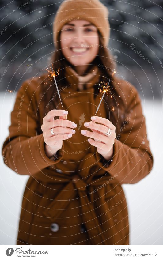 Frau steht im verschneiten Park und hält Wunderkerzen Schnee Neujahr Weihnachten Wetter Feier Tradition im Freien festlich Stimmung Veranstaltung Feuerwerk