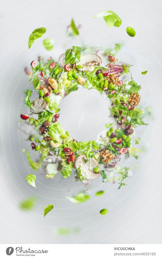 Kreisrahmen von fliegendem gesunden grünen Salat. Ausgewogenes veganes Essen mit Kopierraum. Levitation von Lebensmitteln kreisen Rahmen Gesundheit Salatbeilage