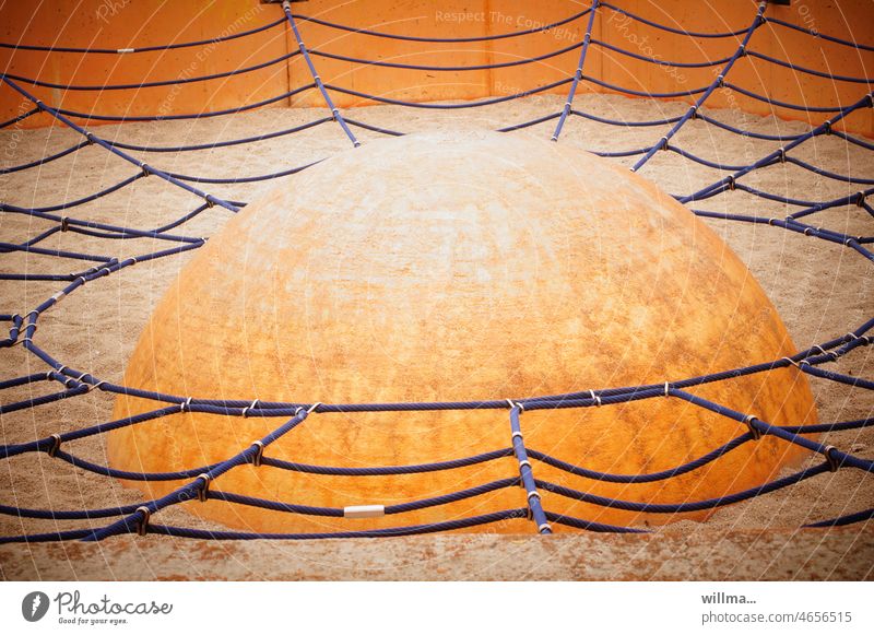 Geschickt getarntes Ufo. Spinnennetzartiges Kletternetz um eine Halbkugel, auf einem Kinderspielplatz. Sie sind unter uns. Netz Spielplatz Balance Gleichgewicht